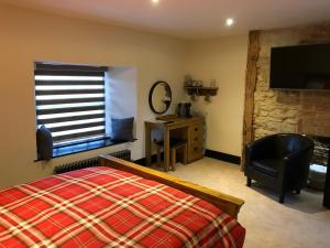 1 dormitorio con cama, ventana y escritorio en The White Hart en Sherington