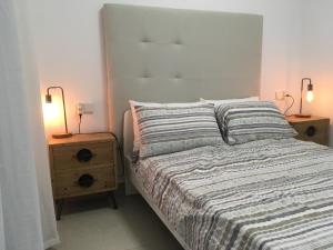 a bedroom with a bed with two night stands and two lamps at Apartment "Las Palmeras" in Los Alcázares +21 photos