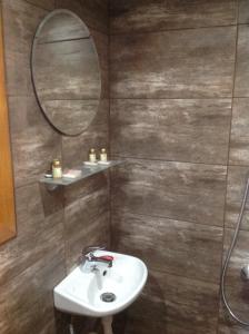 W łazience znajduje się umywalka i lustro. w obiekcie Еднофамилна дървена къщичка w mieście Beli Iskar