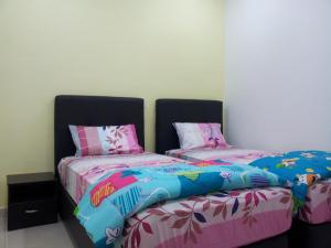 two beds sitting next to each other in a room at Sunshine Jonker Guesthouse in Malacca