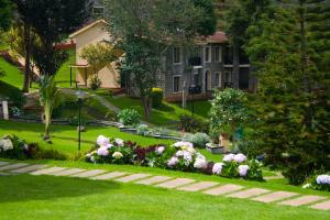 a garden with pink and white flowers in a yard at Green Pastures - A Hill Country Resort in Kodaikānāl