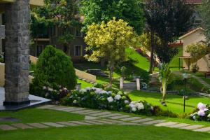 a garden with flowers and trees and a building at Green Pastures - A Hill Country Resort in Kodaikānāl