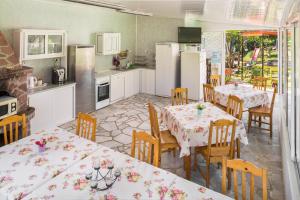 a kitchen with tables and chairs and white appliances at Villa Zelenika in Sinemorets