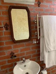 un baño con espejo y lavabo en Sapphire Studio, en Noordhoek 19 fotos más
