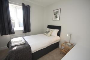a bedroom with a bed with white sheets and a window at The Hanwell in Banbury