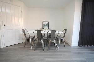 a dining room table with chairs and a white wall at The Hanwell in Banbury