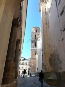 Una vista desde un callejón de un edificio con una torre. en Inn Alta Marea, en Salerno