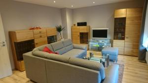 uma sala de estar com um sofá e uma televisão em Gästehaus Sylvia em Kelberg