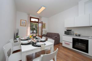 eine Küche und ein Wohnzimmer mit einem Tisch und Stühlen in der Unterkunft Residenza Rocca del Lago in Riva del Garda