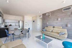 a living room with a couch and a table at Beautiful Sunny 3 bedrooms in font of the beach in Tel Aviv