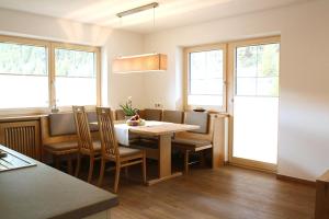 Un comedor con mesa y sillas y ventanas. en Haus Simone, en Sölden 15 fotos más