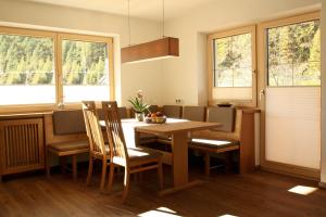 Una cocina con mesa y sillas y ventanas. en Haus Simone, en Sölden