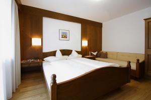 Un dormitorio con una cama grande y un sofá. en Haus Simone, en Sölden