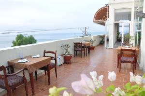 un patio con mesas y sillas y vistas al océano en Nathalie's Vung Tau Hotel, en Vung Tau
