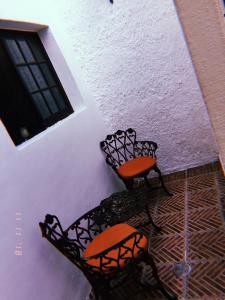 two chairs sitting next to a wall with a window at Maria Bonita in Guadalajara
