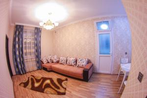 een woonkamer met een bank en een raam bij "METROPOL" APARTMENT HOTEL in Baku