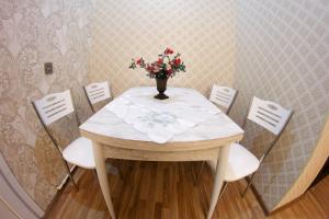 "METROPOL" APARTMENT HOTEL في باكو: طاولة وكراسي عليها إناء ورد