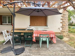 シャルネ・レ・マコンにあるChambre avec vue sur jardinのパティオ(パラソル付きのテーブルと椅子付)