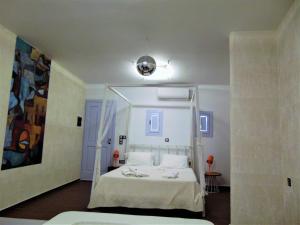 a bedroom with a white bed with a ladder at AMO Folegandros in Karavostasi