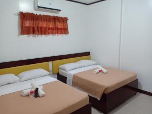 a room with two beds with towels on them at Seashore Beach Resort in Puerto Galera