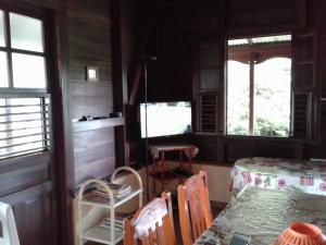 a dining room with a table and two windows at Villa Obaki in Sainte-Anne