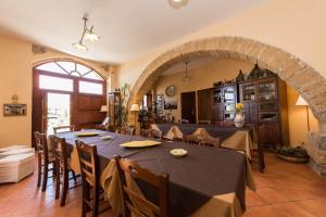 een eetkamer met een tafel en stoelen en een boog bij Villa Palamara 1868 Apartments in Cefalù