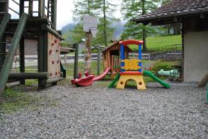 a playground with a slide and a play equipment at Hotel Des Alpes in Kandersteg