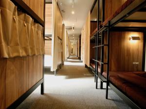 a hallway with bunk beds in a hostel at Namba Guesthouse HIVE in Osaka