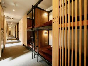 un pasillo con una fila de literas en Namba Guesthouse HIVE, en Osaka