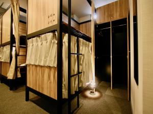 a room with bunk beds with a light in it at Namba Guesthouse HIVE in Osaka