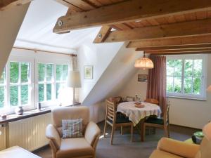a living room with a table and chairs and windows at Ferienwohnung Anne in Nebel