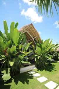 a resort with green plants in front of a building at White Palm Hotel Bali in Jimbaran