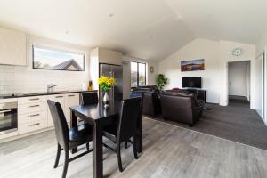 una cucina e un soggiorno con tavolo e sedie di NV Homes a Queenstown