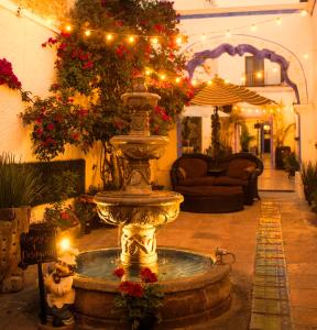 Hotel & Spa La Mansion del B Azul في كيريتارو: نافورة في وسط غرفة بها زهور