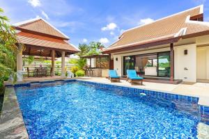 a swimming pool in front of a villa at Villa Bianca in Rawai Beach