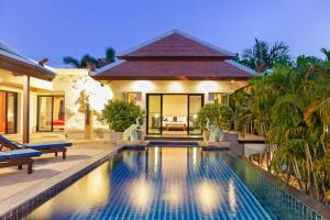 una villa con piscina frente a una casa en Tropical Living at 3BR Pool Villa Bianca, Baan Bua Luxury Estate, Nai Harn Beach, en Rawai Beach