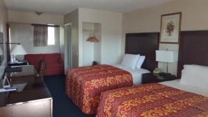a hotel room with two beds and a red couch at Valley Hotel in Rosemead