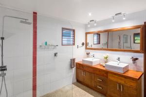 a bathroom with two sinks and a shower at Sea Winds Villa in Singatoka