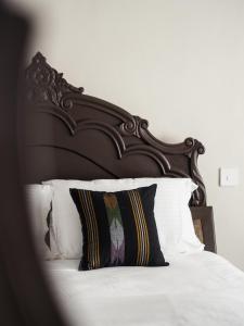 - un lit avec une tête de lit en bois et un oreiller dans l'établissement Omana Hotel, à Katmandou