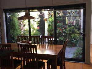 a dining room with a table and chairs and a large window at Brunswick B & B in Melbourne