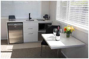uma cozinha com uma mesa com uma garrafa de vinho e flores em Skylark Lodge em Okaihau