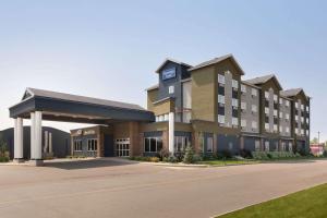 a large hotel building with a parking lot at Travelodge Hotel by Wyndham Weyburn in Weyburn
