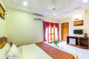 a bedroom with a bed and a desk and a television at Sri Sarvesha JS Palace temple view in Tiruvannāmalai