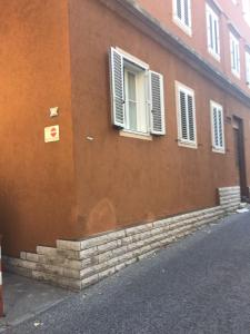 un edificio con finestra e scale di fronte di Casa del Cucciolo a Trieste