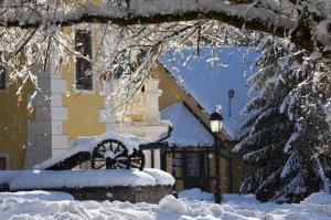 una casa cubierta de nieve con una estatua delante de ella en Penzion pri Kastieli Betliar, en Betliar