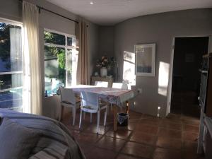 a dining room with a table and chairs at Bramber Cottage Hogsback, Living With Joy! in Hogsback