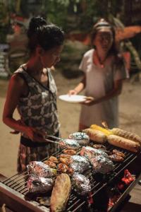 チャン島にあるFreedom homeの二人の女が食べ物を持って焼き物の前に立っている