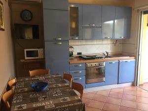 een keuken met een tafel en een keuken met blauwe kasten bij CasaRoberta in Marina di Campo