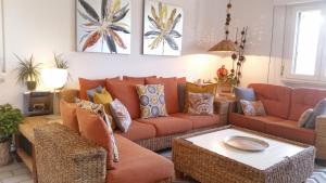 sala de estar con sofás naranjas y mesa en Bettina's wonderful flat, en Riccione
