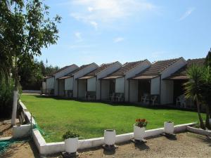 eine Reihe von Häusern mit einem grünen Hof in der Unterkunft Corfu Dream Village in Ýpsos